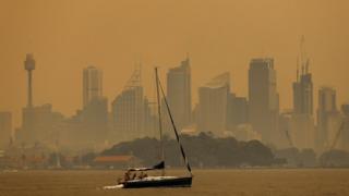 Smoke haze from bushfires turns the sky orange and obscures buildings in Sydney's skyline