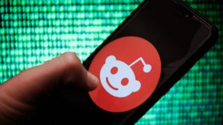 A Reddit logo on a smartphone