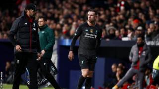 Jordan Henderson feels his hamstring as he walks off the pitch