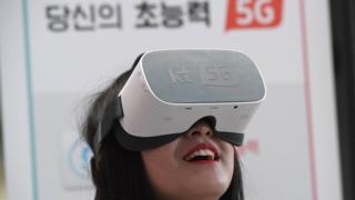 A woman uses 5G services on a virtual reality device in Seoul in April 2019