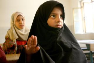 Çocukları başlarını örtmeye zorlamak tartışmalara yol açan bir konu. Fotoğraf 2004 yılında, Saddam sonra Bağdat'tan