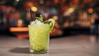 Un trajo con kiwi sin alcohol sobre una barra.