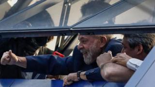 Ex-presidente Lula acena para público de dentro do prédio do Sindicato dos Metalúrgicos do ABC