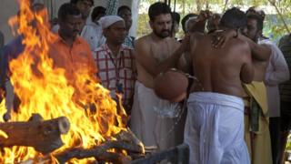 Отец жертвы, Мадхусудхан Рао, совершает ритуалы вокруг тела своего сына