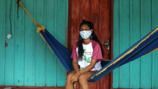 An indigenous woman in the Amazon, in Brazil, wearing a protective face mask.