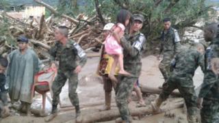 Soldado carrega menina durante operação de resgate