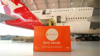 Boxes of face masks are loaded onto a Qantas A-380 aircraft at LAX Airport.