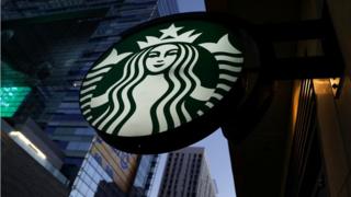 Знак Starbucks висит в Лос-Анджелесе, штат Калифорния