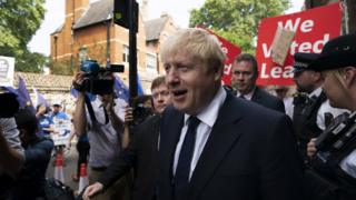Johnson caminha em rua de Londres acompanhado por fotógrafos e manifestantes pró-Brexit