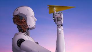 Un robot con un avión de papel doblado