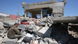 This file photo taken on March 26, 2017 shows an Iraqi man amid the rubble of destroyed houses in the Mosul al-Jadida area, following air strikes in which civilians have been reportedly killed during an ongoing offensive against the Islamic State (IS) group. U