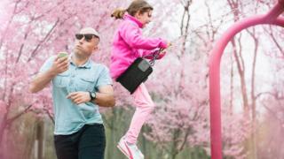 Father gets hit by his daughter on the swing while watching smart phone