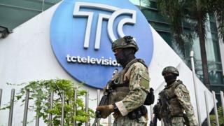 Soldiers patrol outside the broadcast channel targeted by gangs earlier this week