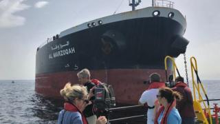 Journalists view the damaged Saudi oil tanker Al-Marzoqah in the Gulf, 13 May