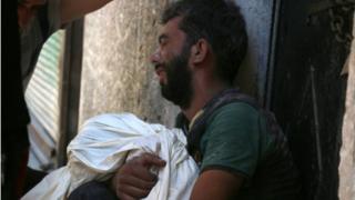 A Syrian man mourns the death of a child following reported air strikes on 16 July 2016 in the rebel-controlled neighbourhood of Saleheen in the northern Syrian city of Aleppo.