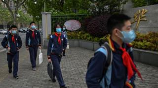 طلاب يرتدون أقنعة الوجه لدى وصولهم إلى مدرستهم، في شنغهاي، الصين، يوم 27 أبريل/نيسان 2020