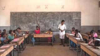 Olukọ kan duro, o n kọ awọn akẹkọ