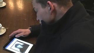Marco Hauenstein looking at mother's image on tablet