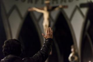 Hombre frente a Cristo levantando la mano