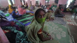 Evacuated people sit in a temporary cyclone relief shelter as Cyclone Ampha