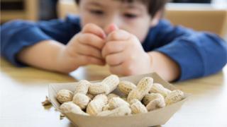 Niño comiendo cacahuetes o maníes
