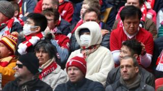 Fans uses masks at a Premier League game