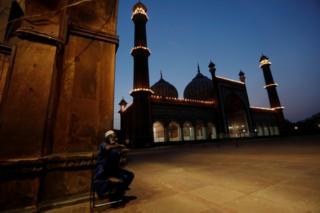 Ein Mann bricht sein Fasten vor der leeren Jama Masjid in Delhi