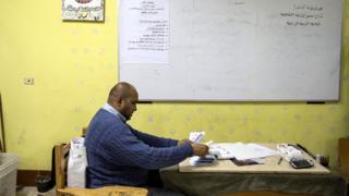 Man counting ballots at a desk