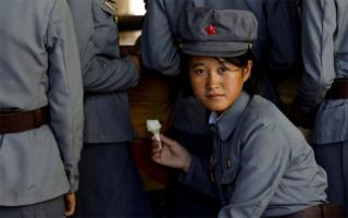 A soldier eats ice cream as she visits a zoo in Pyongyang, North Korea