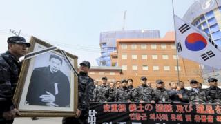 Ветераны Южной Кореи держат в рамке портрет Ан Чжон Гына во время митинга, посвященного 100-летию со дня его смерти
