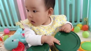 Baby Yiyi обнимает канистры с молочной смесью
