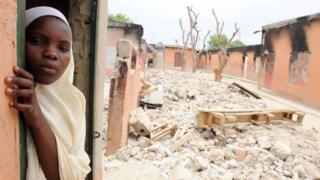 Студентка стоит в сгоревшей классной комнате в школе в Майдугури, Нигерия, 12 мая 2012 года