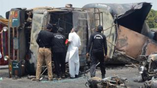 La policía revisa el camión de combustible que explotó y se quemó el 25 de junio en Punyab, Pakistán.
