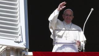 Pope Francis waves as he leads his Angelus prayer in Saint Pater's square at the Vatican