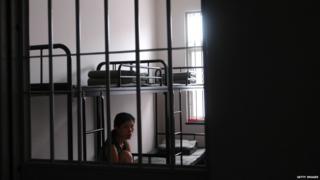 A woman inmate looks out of a ward at a detention centre 24 June 2005