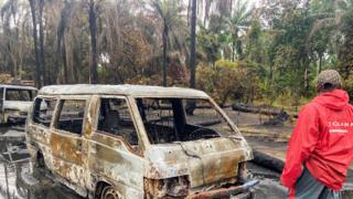 Un hombre cerca de vehículos quemados después de una explosión en una refinería ilegal de petróleo en el Delta del Níger, Nigeria - Abril de 2022