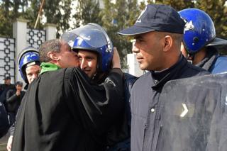 An Algerian lawyer kisses a policeman during a protest against ailing president's bid for a fifth term in power, in Algiers on 7 March 2019.