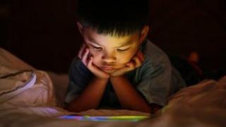Anak melihat layar tablet.