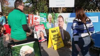 An electioneer handouts how to vote cards at a voting booth in Balwyn for the seat of Kooyong during Election Day in Melbourne, Australia, 18 May 2019