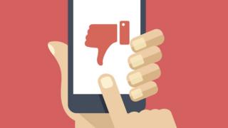 Ilustração de uma mão segurando um celular - na tela, há um símbolo de uma mão com o polegar para baixo