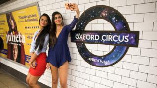Dos jóvenes se hacen una selfie en el metro de Londres.