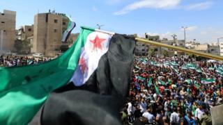 Syrian protesters wave their national flag as they demonstrate against the regime and its ally, Russia, in the Idlib town held by the rebels on September 7, 2018