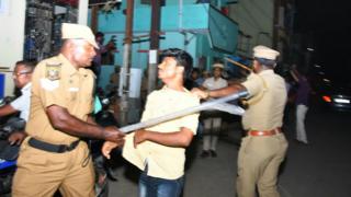 இளைஞர்களைய அடிக்கும் காவல்துறையினர்.