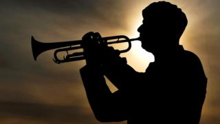 Solder plays last post against backdrop of setting sun