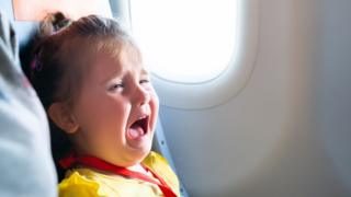 طفلة تبكي في طائرة
