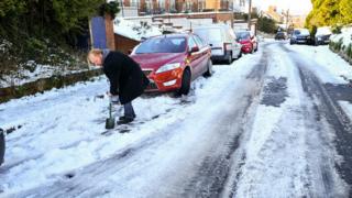 Man clears snow in Westbury, Wiltshire, on 2 February 2019