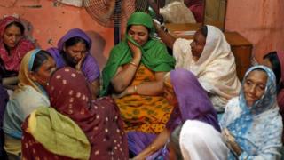 The daughter (C) of Divan Ayubsha Bafaisha, 65, and Divan Jubedabibi Aiyubsha, 62, an elderly couple who died in a stampede during the haj last week in Saudi Arabia, is consoled by unidentified women inside her parent"s house in Jargal in the western state of Gujarat, India, September 26, 2015.