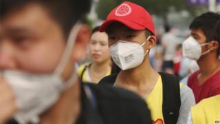 Волонтер (С) носит маску во временном убежище после взрывов в Тяньцзине 14 августа 2015 года.