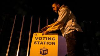 An IEC official takes off a sign that gives directions to the polling station moments before the station closed at the Christiaan de Wet School on 8 May 2019 in Sophiatown, on the outskirts of Johannesburg, South Africa.