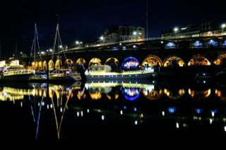 Reflections of boats and lights in water
